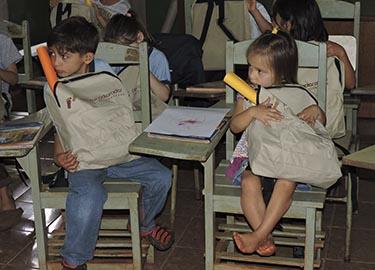 Niños sentados en los pupitres de la escuela