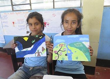 Niñas mostrando sus dibujos
