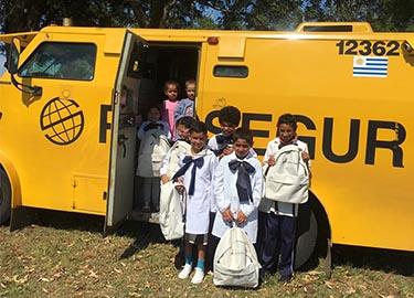 Niños al lado de un furgón de Prosegur Niños al lado de un furgón de Prosegur