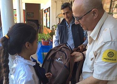 Voluntario entregando mochila a una niña Voluntario entregando mochila a una niña