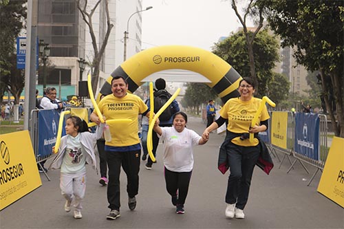 Voluntarios y niños participando en una carrera Voluntarios y niños participando en una carrera